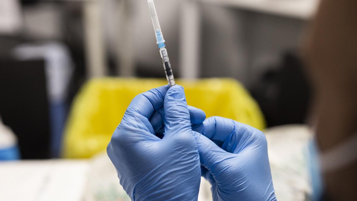 Un sanitario sostiene una dosis de la vacuna de Pfizer