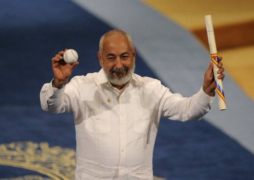Cuban author Leonardo Padura holds up a baseball after receiving the 2015 Princess of Asturias award for Literature from Spain's King Felipe during a ceremony at Campoamor theatre in Oviedo