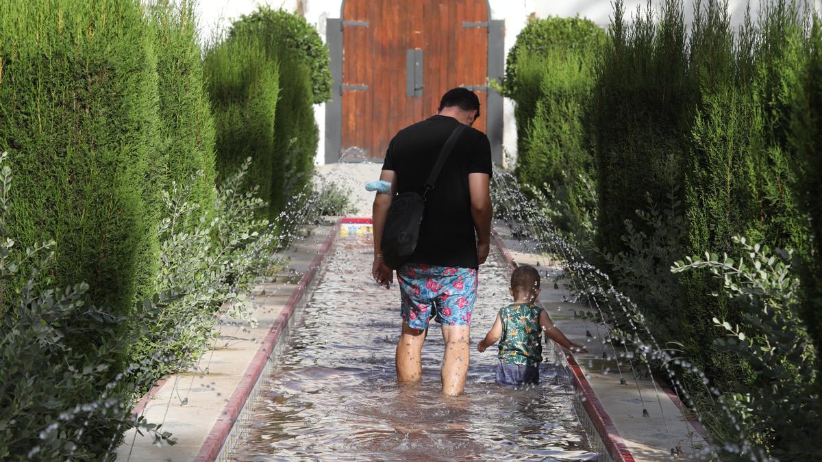 Una padre y su pequeño se refrescan en Elche