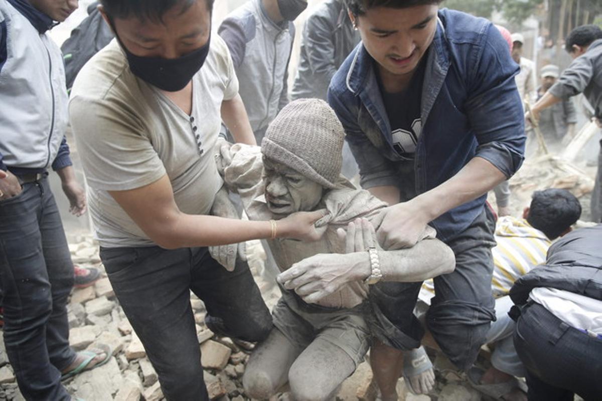 Los voluntarios logran rescatar a un hombre de los escombros de un edificio destruido en Nepal.