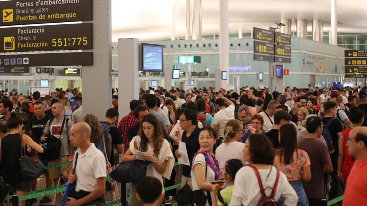 Colas para pasar el control de seguridad de la T-1, en el aeropuerto de El Prat.