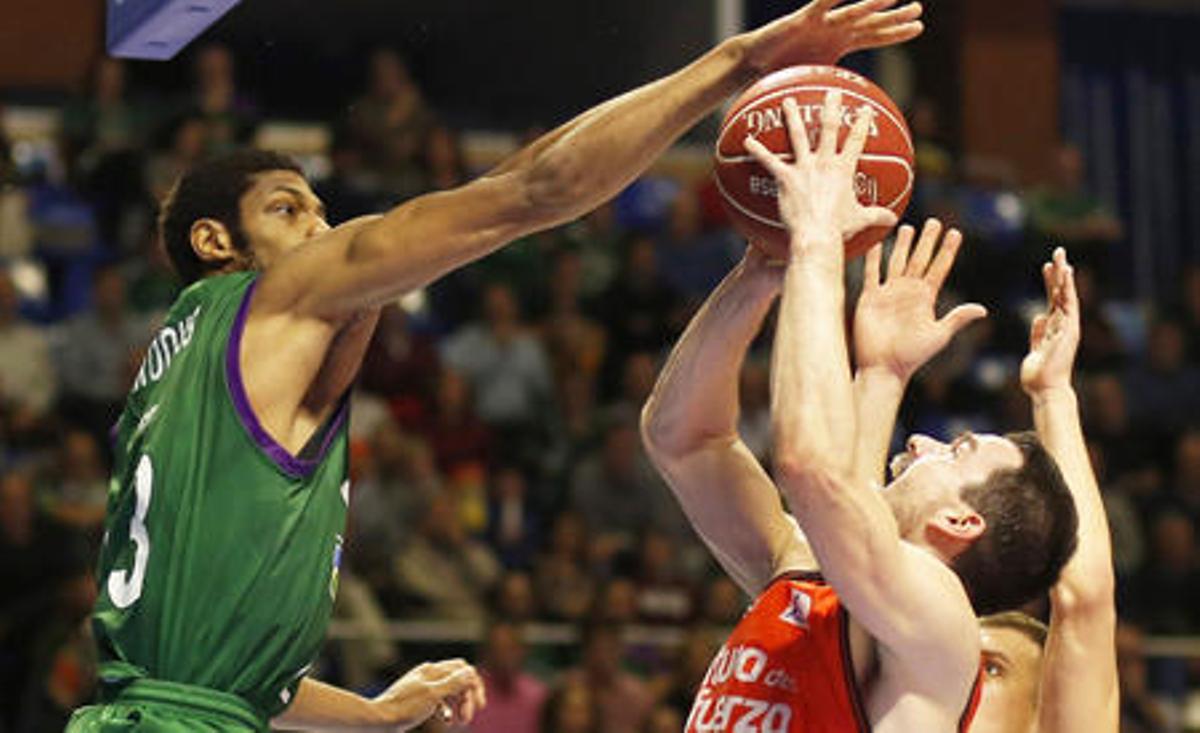 Jeff Brooks (i) le hace un tapón al escolta del Valencia Basket Rafa Martínez (c)