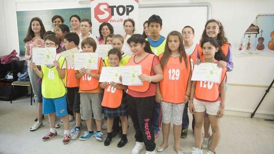 Varios niños posan con su diploma de las rutas escolares seguras. 13fotos