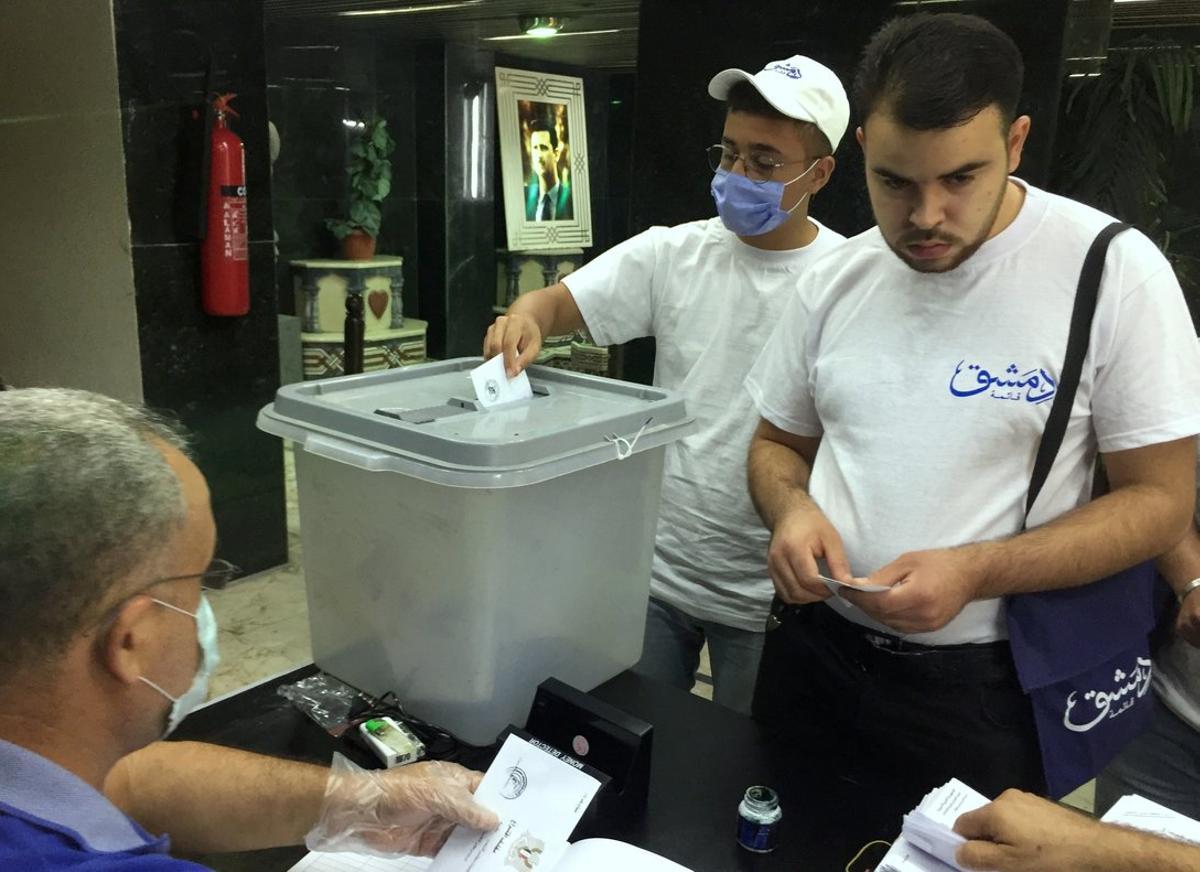 A man wearing a face mask casts his vote inside a polling station during the parliamentary elections in Damascus, Syria July 19, 2020. REUTERS/Omar Sanadiki