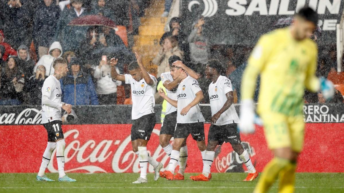 Los jugadores del Valencia festejan un gol bajo una cortina de agua