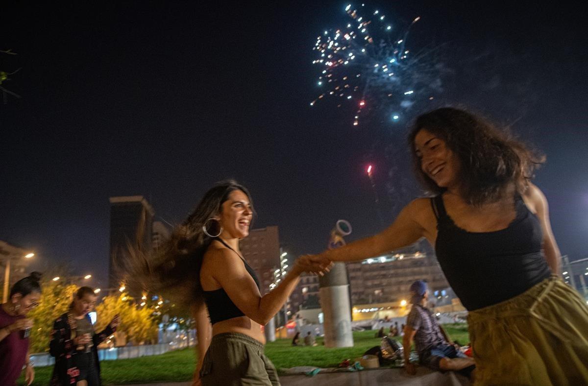 Unas chicas bailan alegremente, en el parque Joan Miró, durante la verbena.