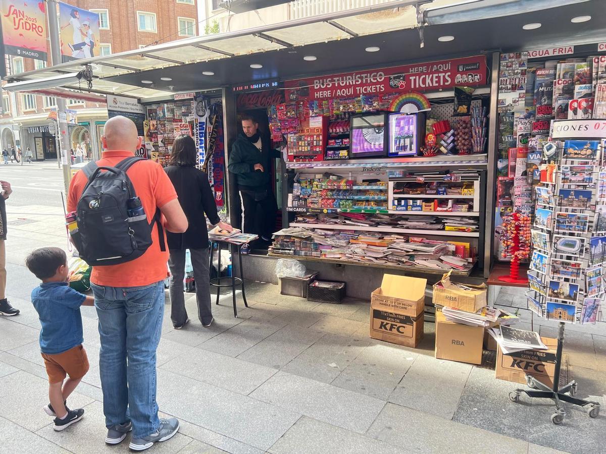 Óscar atienda a clientes en su quiosco de Gcran Vía.