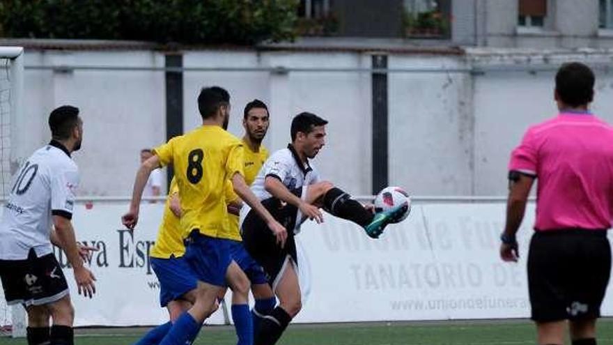 Borja Navarro controla el balón entre varios jugadores de L´Entregu.