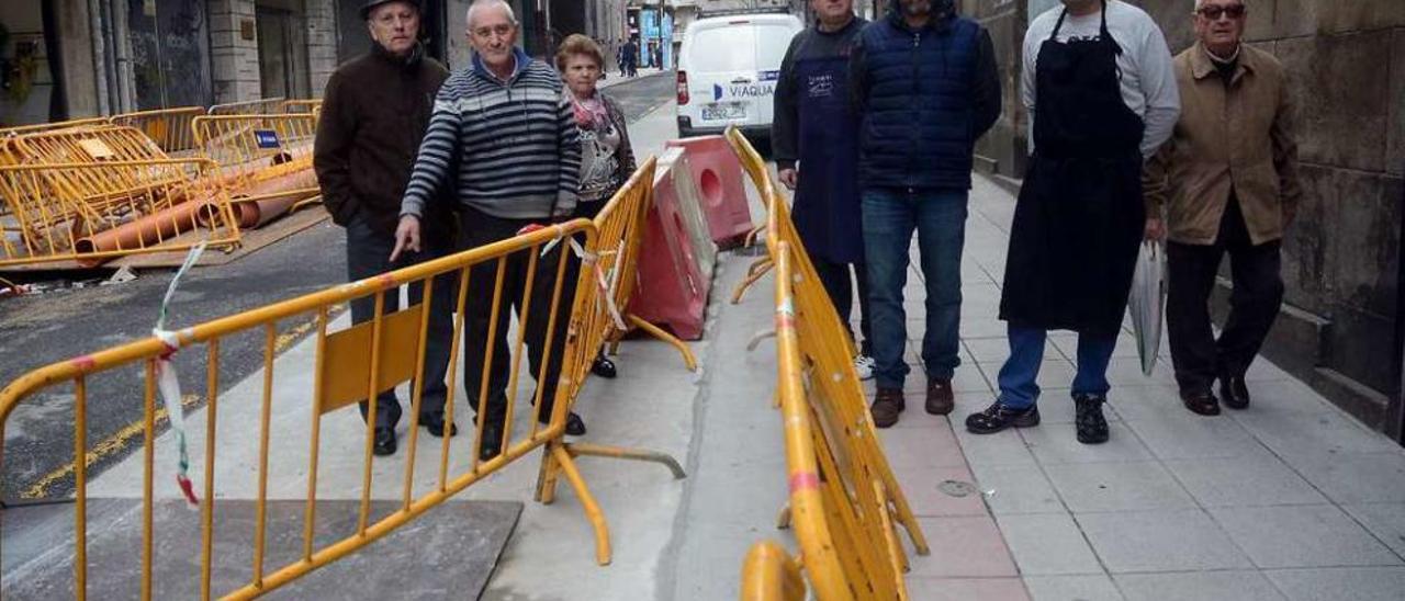 Vecinos que se quejan del retraso de la obra, en la zona del túnel. A la derecha, el viejo sanatorio. // R. V.