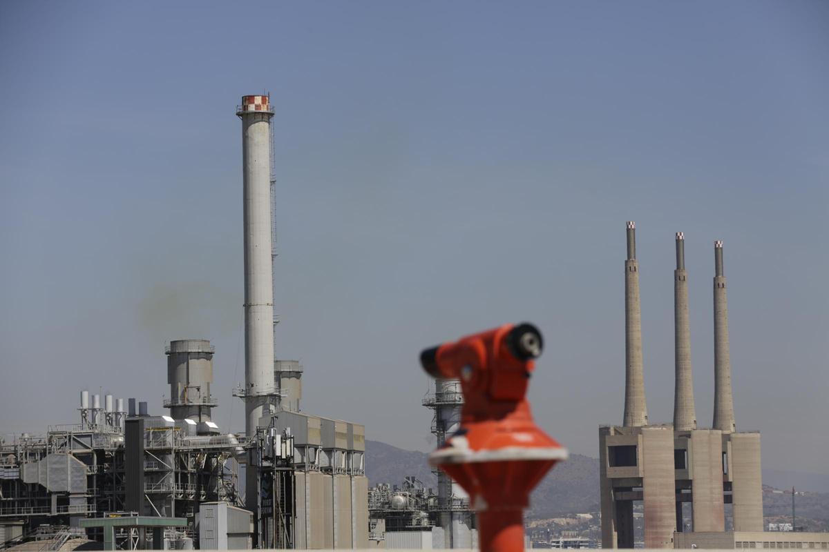 La chimenea de Tersa vista desde el parque del Fòrum, con las Tres Xemeneies al fondo, en Sant Adrià de Besòs.