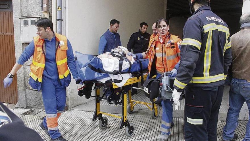 El trabajador es trasladado en camilla a una ambulancia. // Santos Álvarez