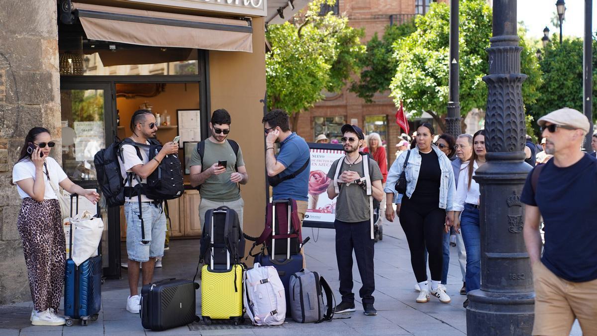 Turistas con maletas de equipaje en el centro de Sevilla