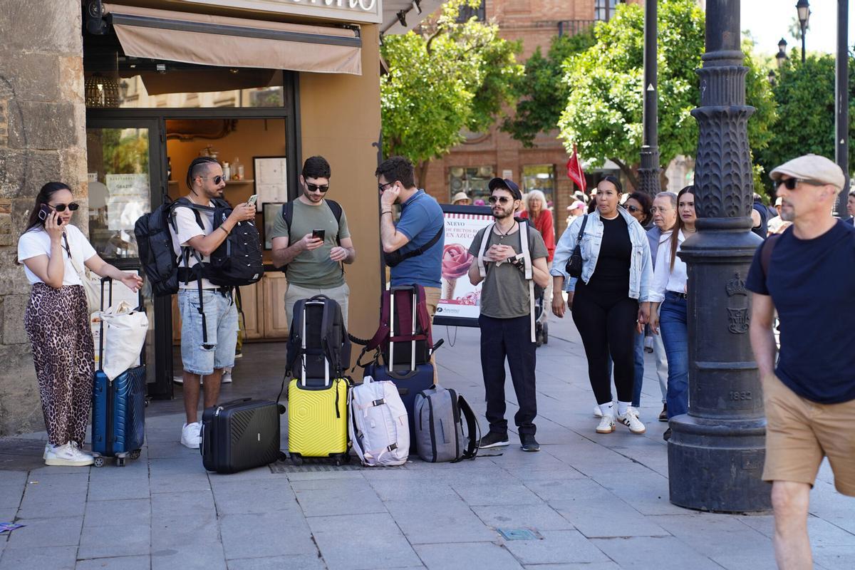 Turistas con maletas de equipaje en el centro de Sevilla