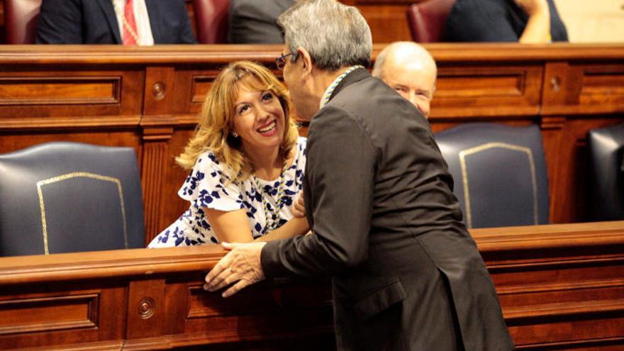 El consejero de Hacienda, Román Rodríguez, habla con su predecesora, Rosa Dávila, en el Parlamento.