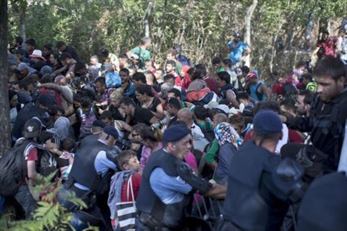 Immigrants i refugiats trenquen el cordó policial a Tovarnik, ahir.