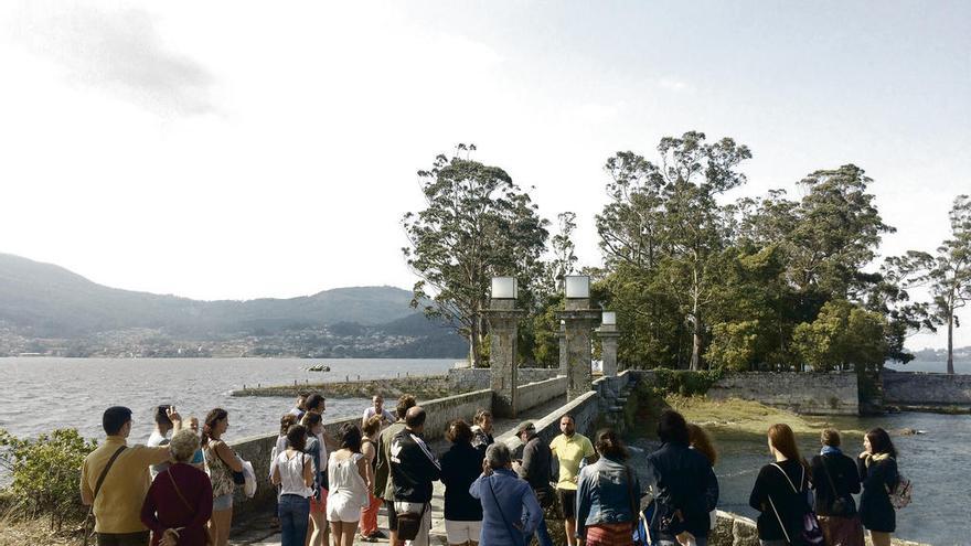 Un grupo de visitantes, en el puente entre ambas islas, atienden a la explicación del guía.// E.B