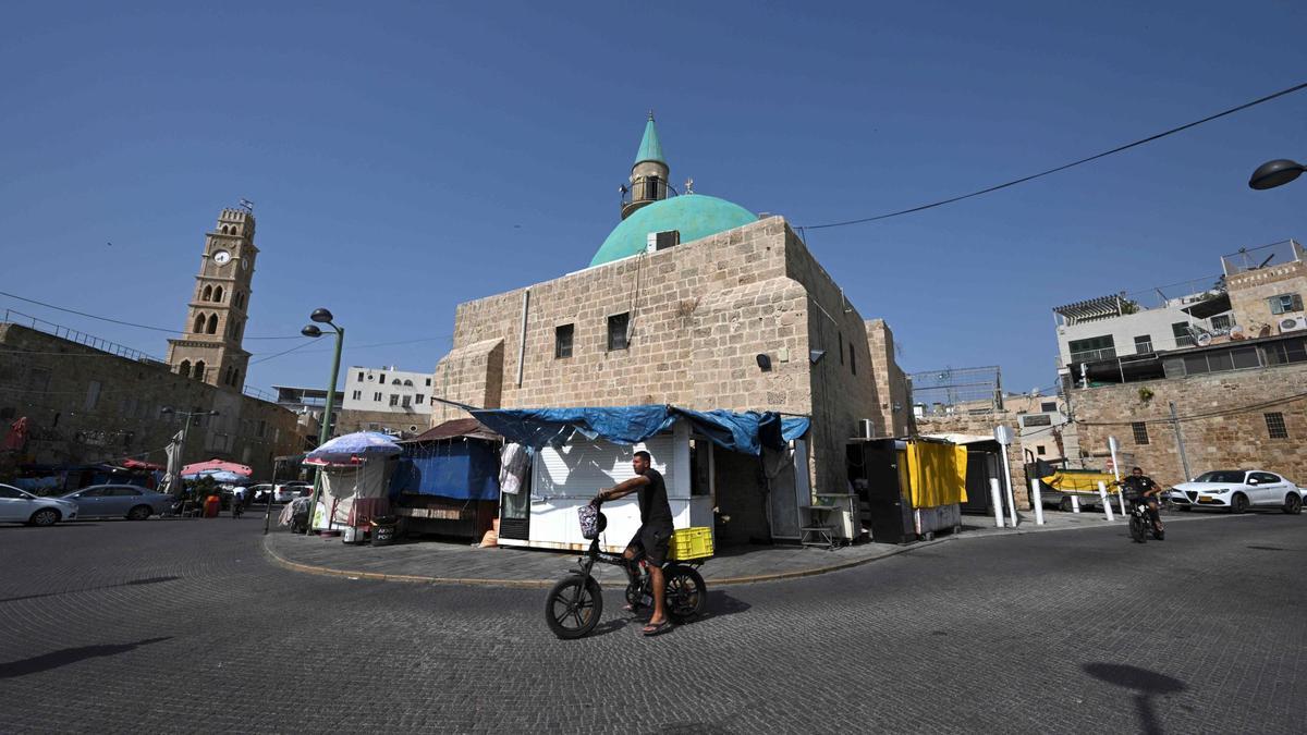 Un ciclista pasa junto a una mezquita en la ciudad israelí de Acre, el 22 de octubre.