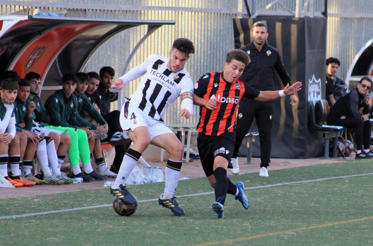 El central albinegro Sergi Miñana pelea un balón en el centro del campo con un rival.