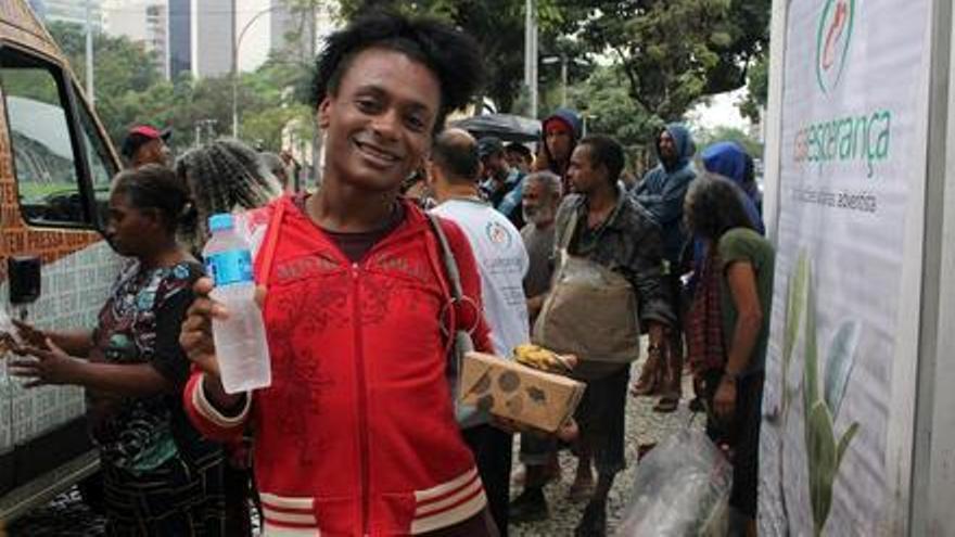 Lara, una mujer trans que vive en la calle, recibe una ración de comida en el centro de Río de Janeiro.