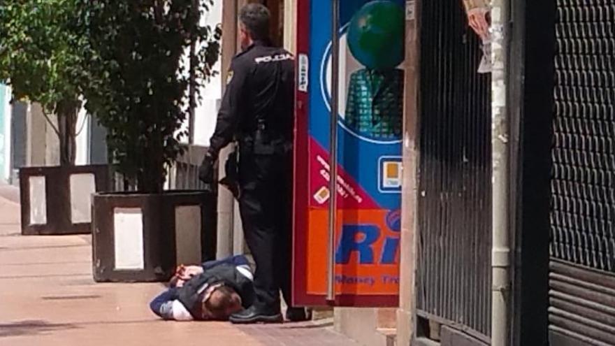 Un policía, junto al sospechoso esposado en el suelo.