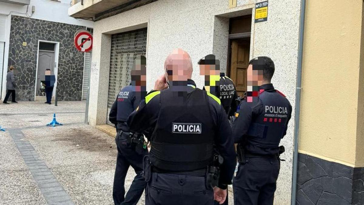 Agents de la Policia Local de Llançà i dels Mossos d'Esquadra davant del bloc que van desallotjar.