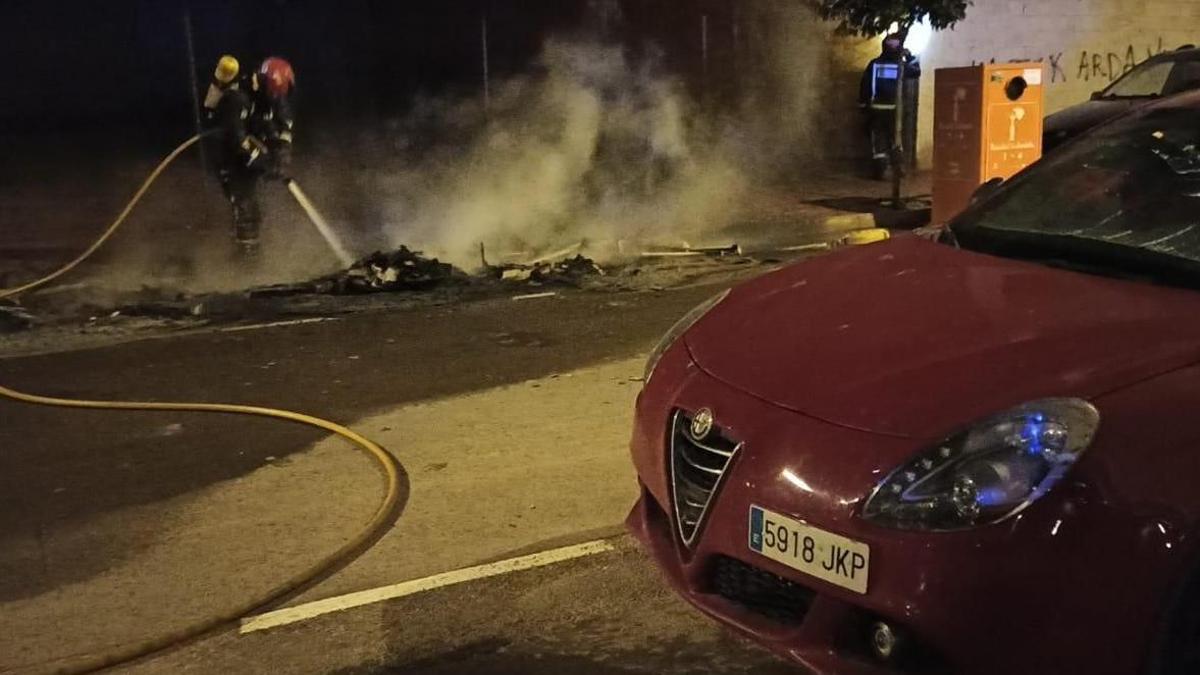 Imagen de un bombero sofocando uno de los incendios de contenedores en Vinaròs