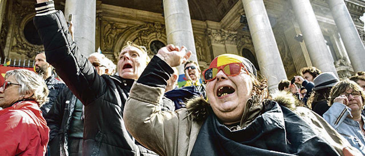 Unos manifestantes, ayer, ante el edificio de la Bolsa de Bruselas contra los atentados y por la paz.