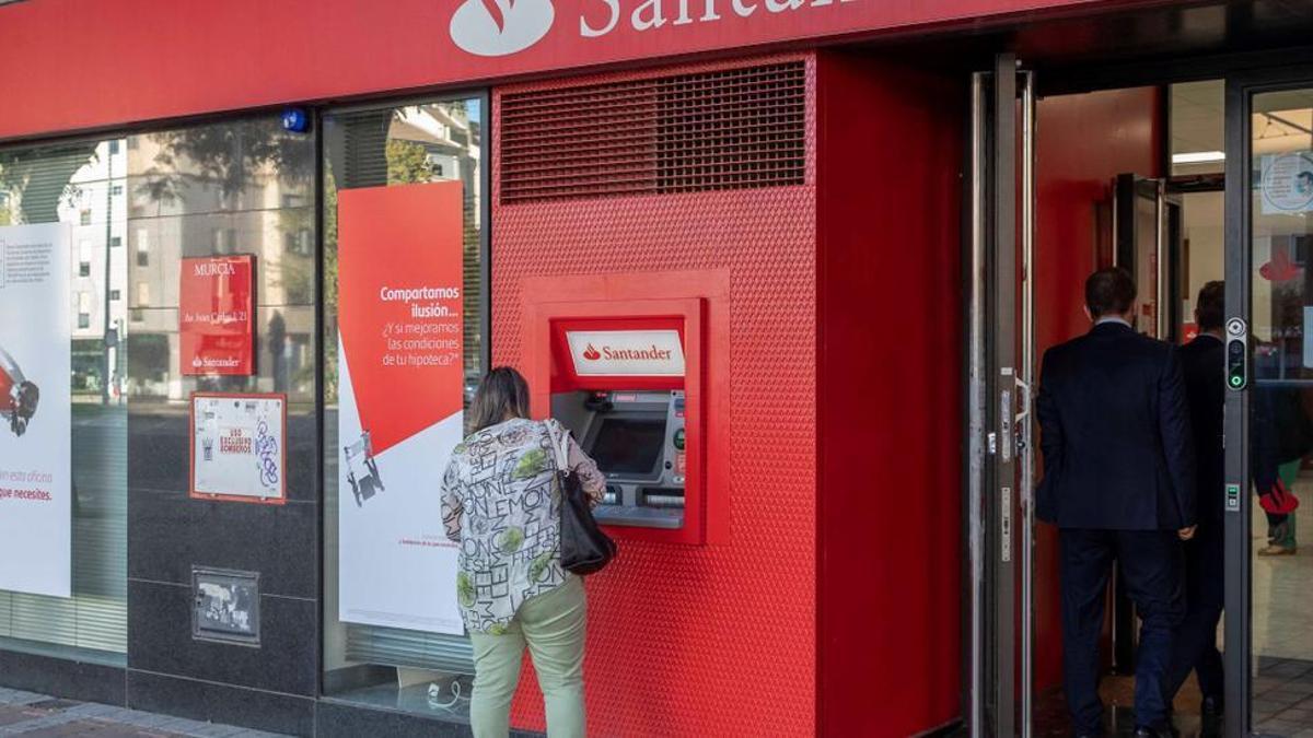 Una mujer saca dinero en un cajero automático de un banco.