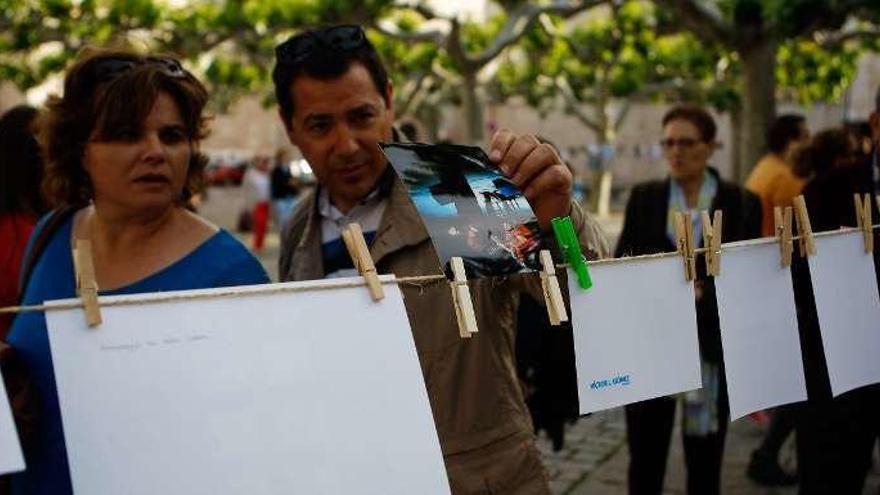 Curiosos ojean una de las fotografías &quot;tendidas&quot; en Viriato.