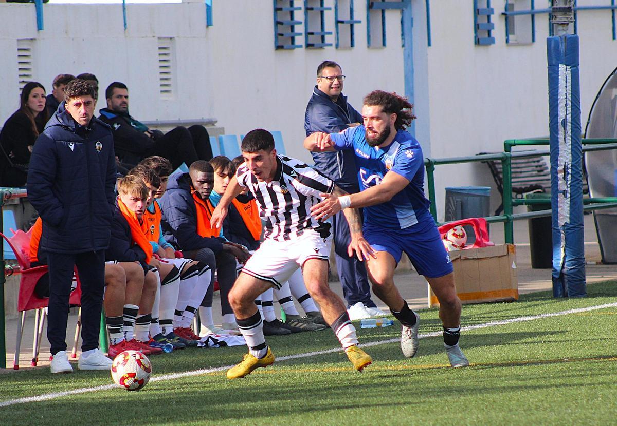 Alejandro Alcira protege el balón ante el acoso del ariete Ferran Giner.