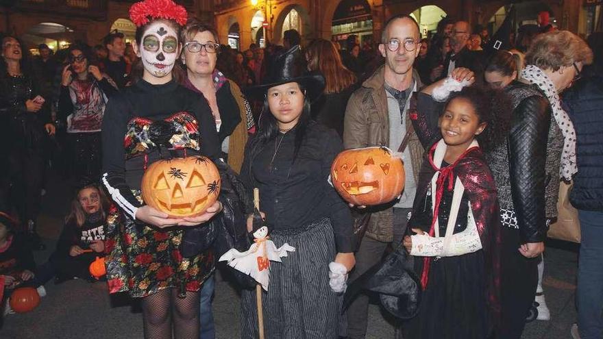 Catrina, bruja y vampiresa posan con las calabazas talladas en el taller. // Iñaki Osorio