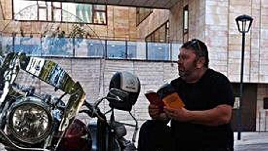 Óscar Sastre con su moto y su libro.