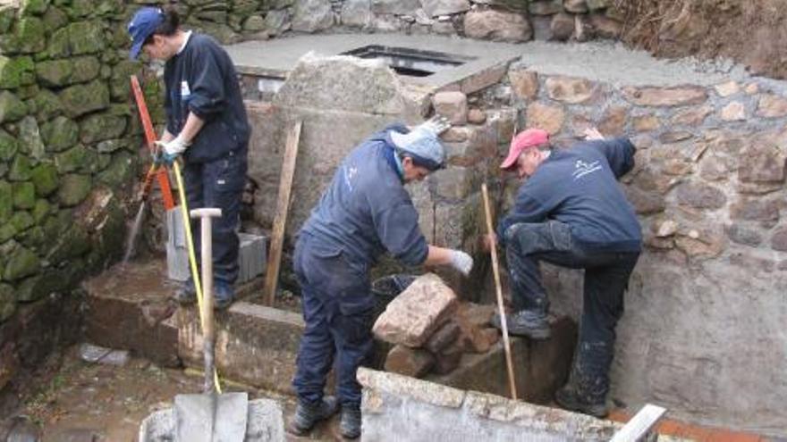 Los operarios, trabajando en la recuperación de la fuente. | b. fernández