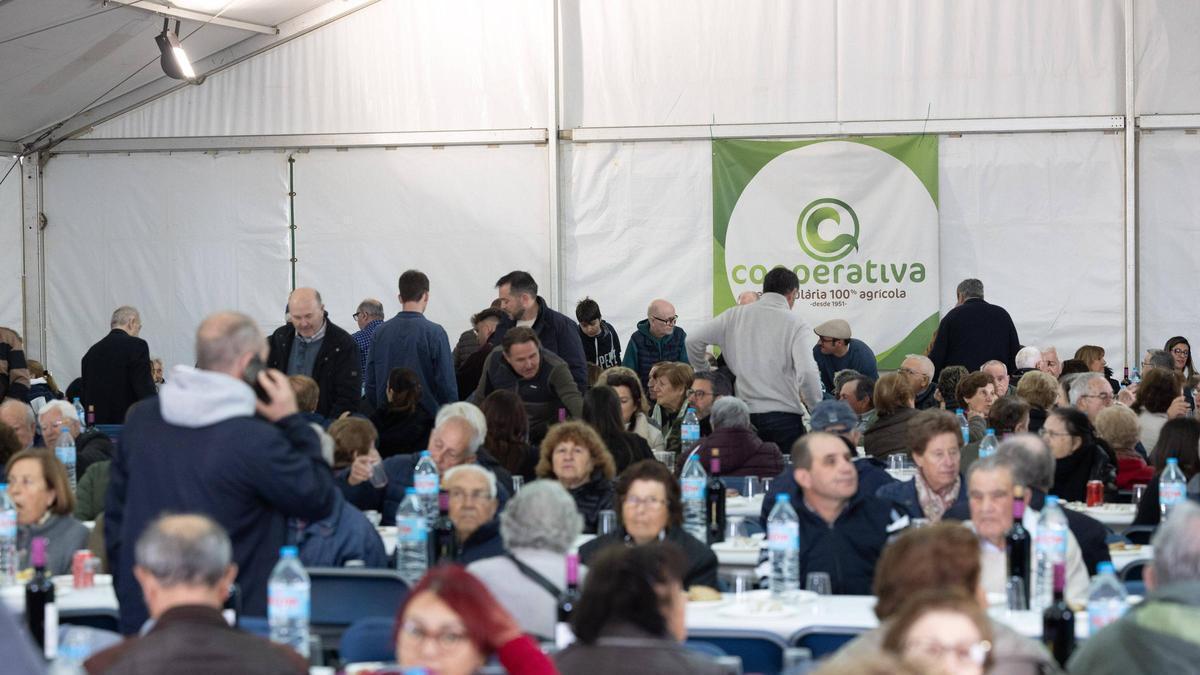 Público y asistentes a la asamblea esperando para comer en la cooperativa agrícola.