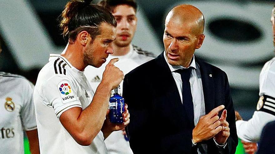 Zidane conversa con Bale en el duelo ante el Mallorca.