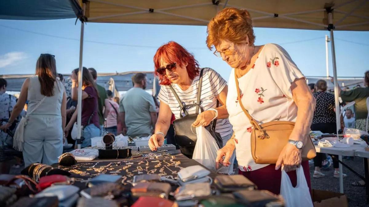 Dos mujeres observan algunos de los artículos a la venta durante una jornada del mercadillo de Mérida.