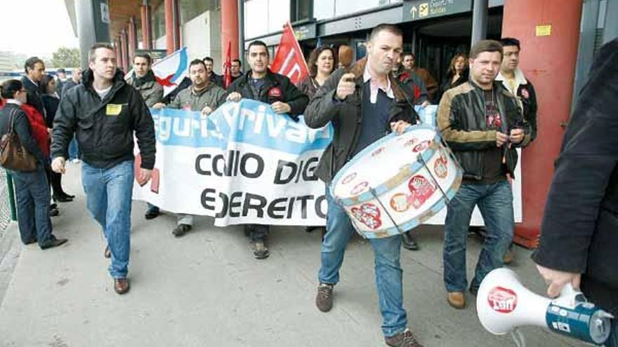 Los huelguistas abandonan el interior de la terminal de Peinador luciendo sus pancartas.