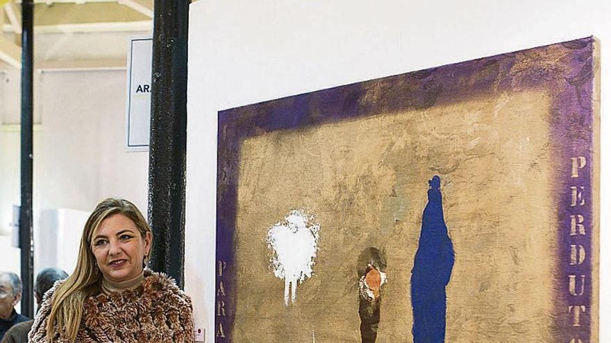 La galerista Angélica García, junto a la obra premiada.