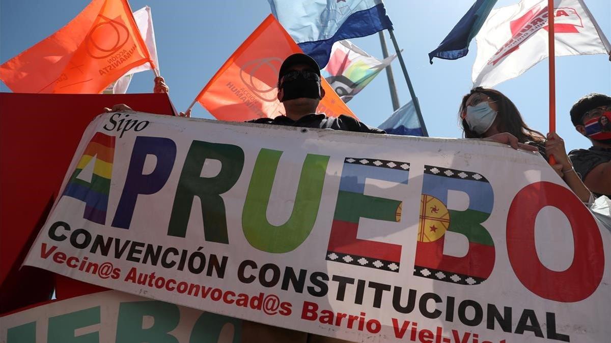 Un partidario de una nueva Constitución en Chile ondea una bandera con el lema 'apruebo', este jueves en una manifestación en Santiago.