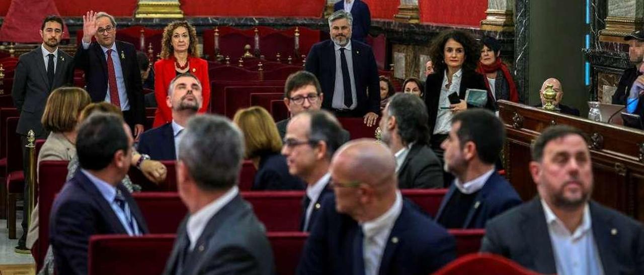 Saludo. Torra, flanqueado por los consejeros catalanes Damià Calvet y Ester Capella (y, a la derecha, el diputado de JxC Albert Batet), saluda a los doce encausados. Todos se vuelven excepto Oriol Junqueras, Santi Vila y Carles Mundó. Sentados, de izq. a dcha. y de adelante a atrás: Joaquim Forn, Raül Romeva y Junqueras; Josep Rull, Jordi Turull y Jordi Sànchez; Dolors Bassa (tapada), Carme Forcadell y Jordi Cuixart; Meritxell Borràs, Vila y Mundó. // Efe