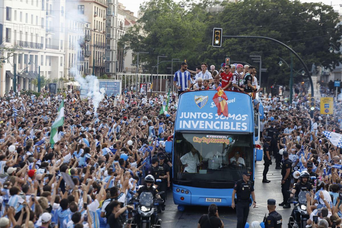 Jugadores y cuerpo técnico del Málaga celebran este lunes por las calles de la capital malacitana el ascenso a Primera División conseguido el pasado sábado en el encuentro que disputaron frente al Almería