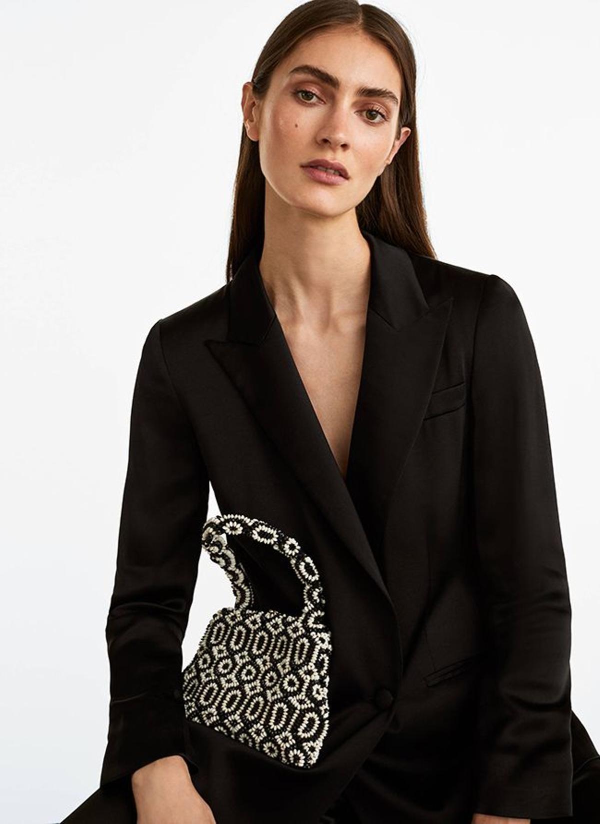 Bolso con asa de mano y detalle de abalorios de blanco y negro, de Uterqüe