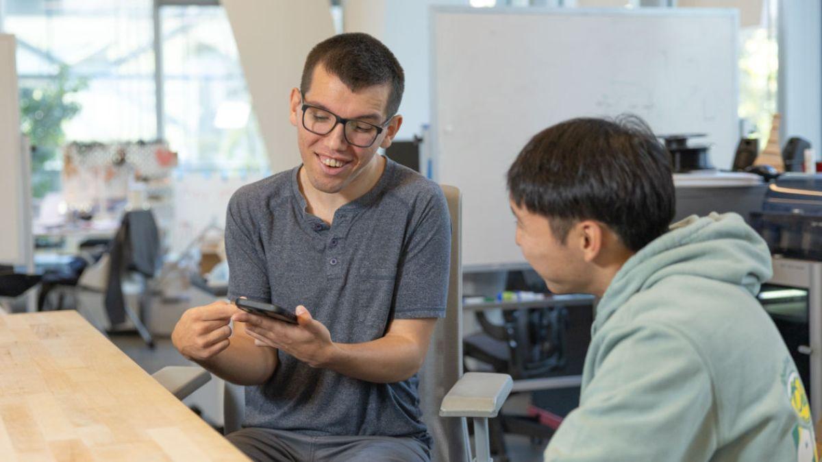 El estudiante de doctorado Tobias Weinberg se comunica con otro estudiante utilizando su software de comunicación aumentativa y alternativa (AAC).