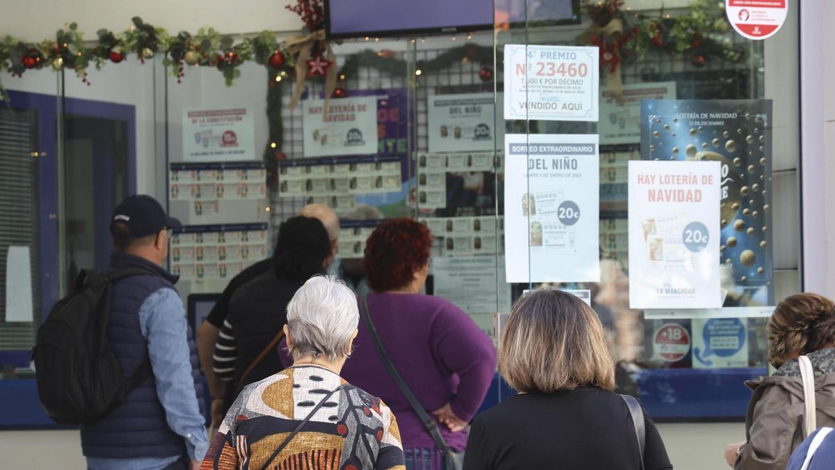 Varias personas en una administración que vende Lotería de Navidad.