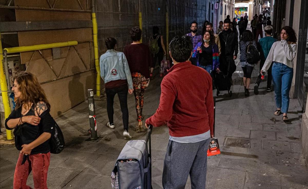 Un latero vende cervezas en una calle de Gràcia.