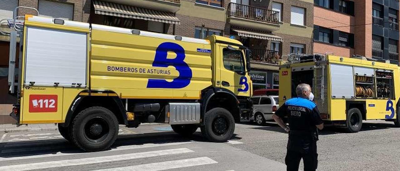 Un agente de la Policía Local y dos camiones de bomberos, ayer, en El Berrón.