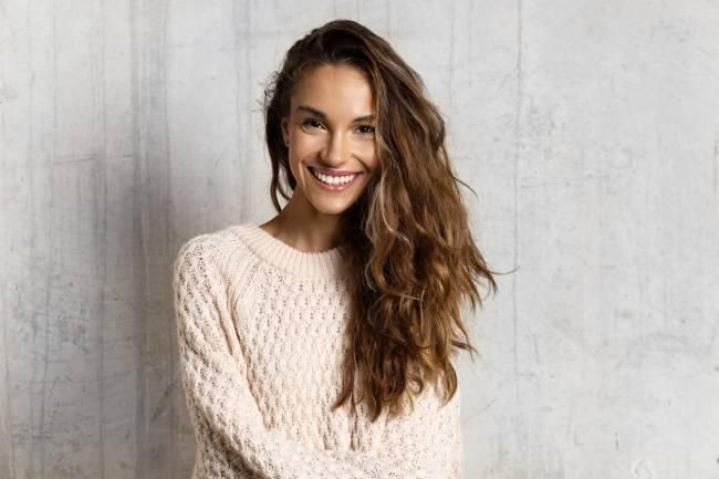 Chica sonriente con jersey blanco