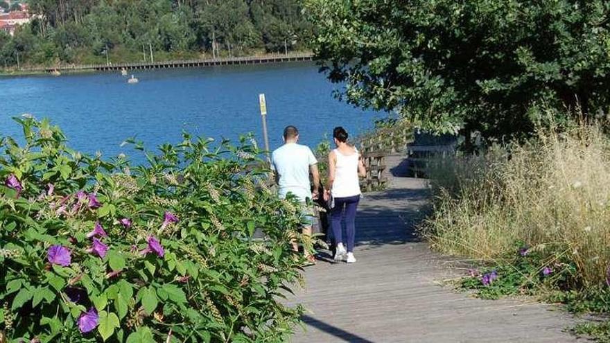 Unas personas transitan por el paseo de A Portela, ayer por la tarde. // FdV