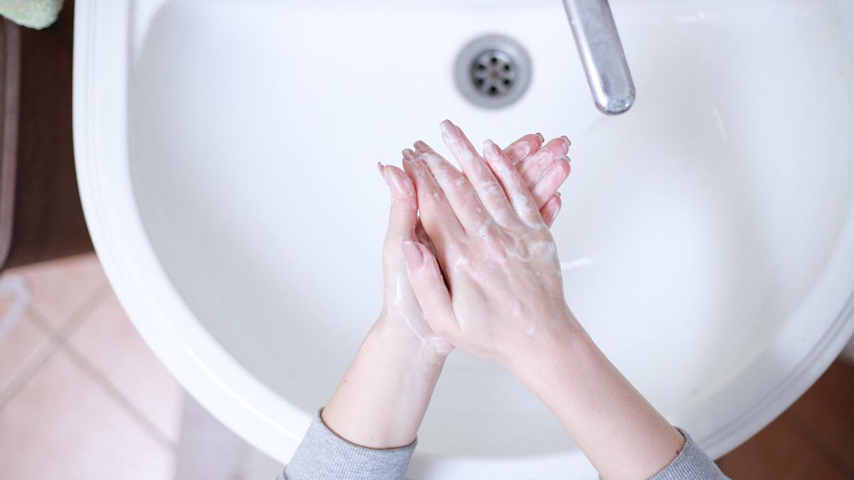 Una persona se lava las manos en su lavabo