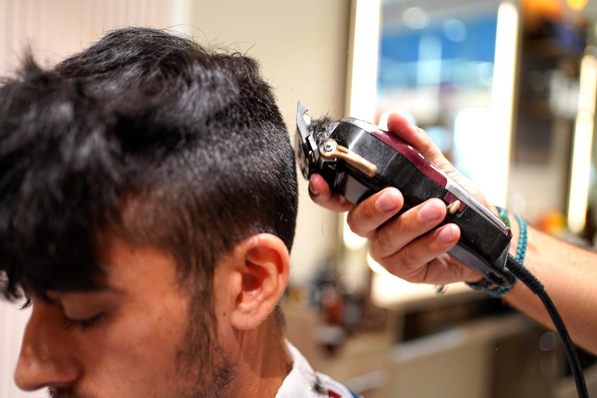 Un chico se corta el pelo en una barbería de Madrid.